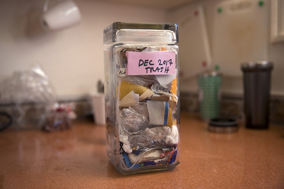 caption: A jar storing all of the waste that Deb Seymour has accumulated in the month of December is shown in the kitchen of her home on Wednesday, December 20, 2017, in Seattle. 