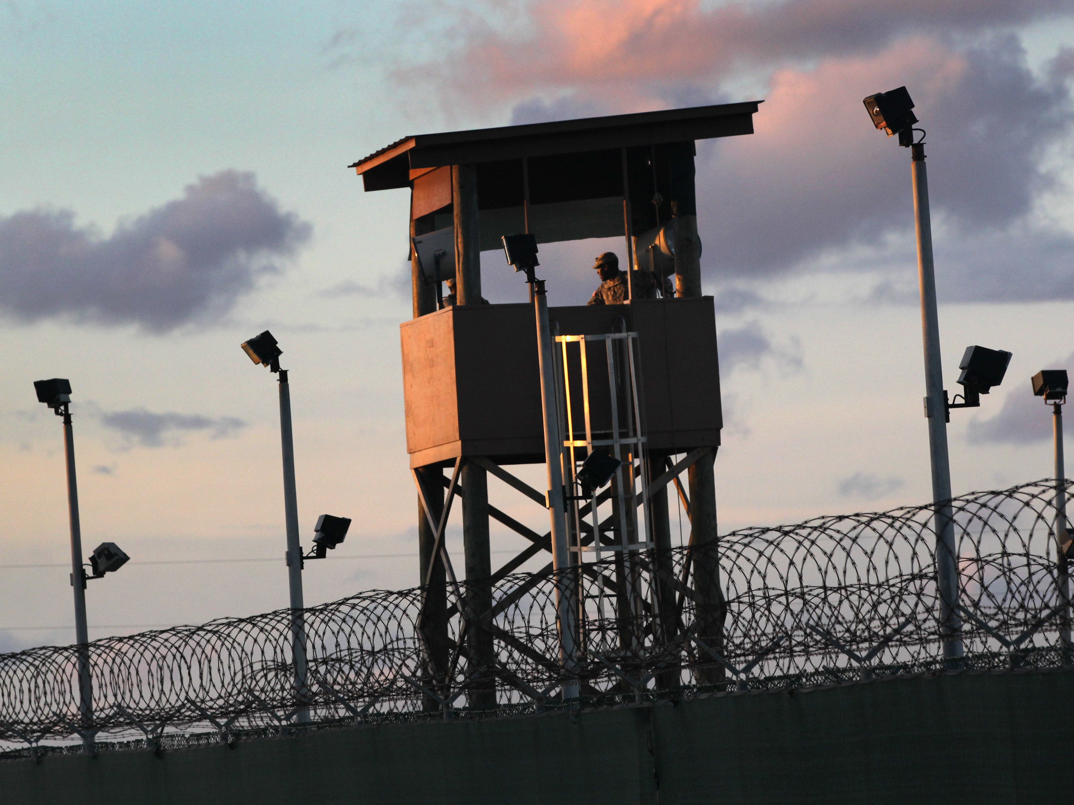 caption: A U.S. military guard tower stands on the perimeter of the detainee camp on September 16, 2010, in Guantánamo Bay, Cuba. There are now 39 detainees remaining after the prisoner transfer on July 19, 2021.