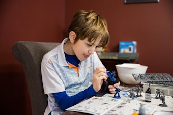 caption: Ten-year-old Landon paints a model at his family's dining room table in Vancouver, Wa., Thursday, Feb. 28, 2019.