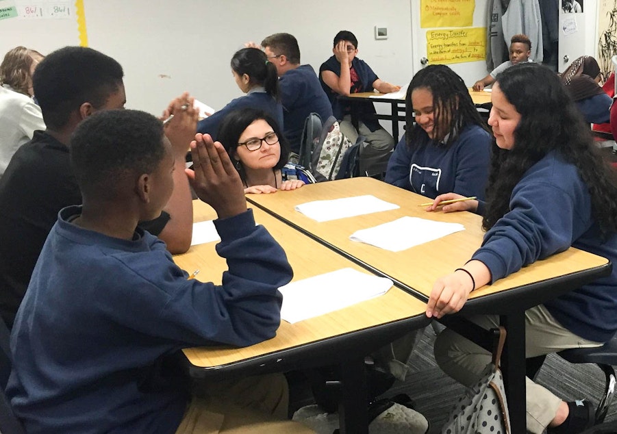 caption: At Excel Public Charter School in Kent, Academic Intervention Specialist Mona Swanson works with students in a science class.