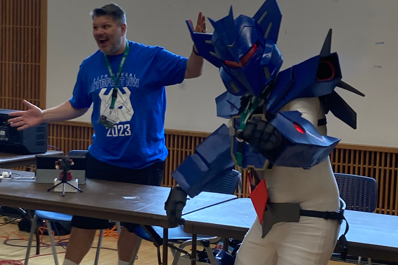 caption: Mike Seibert and a Transformers cosplayer at a Cybfest NW convention in Kent. Seibert has hosted a Transformers podcast for nearly a decade. 