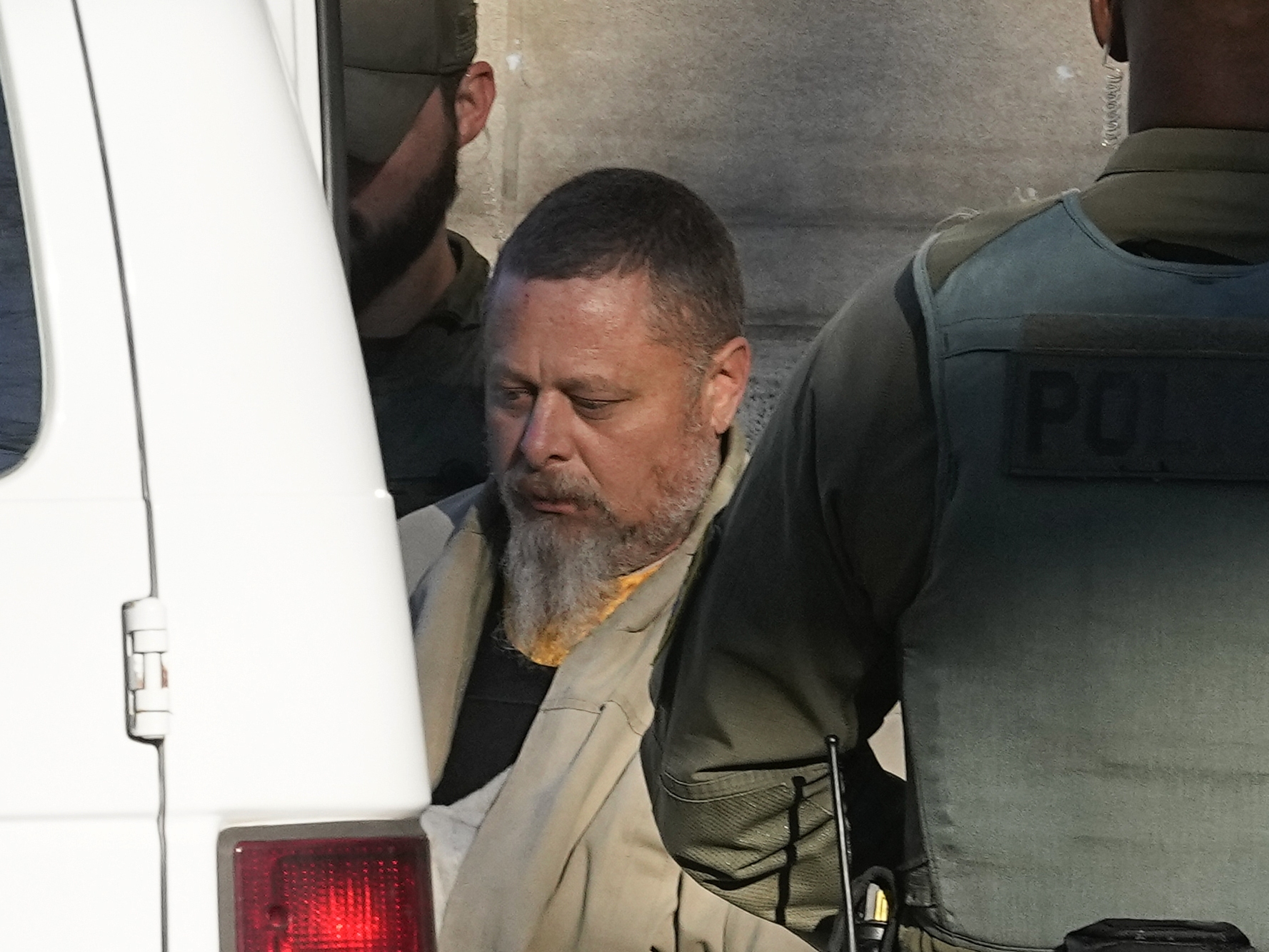 caption: Officers escort Richard Allen out of the Carroll County Courthouse following a hearing Nov. 22, 2022, in Delphi, Ind.