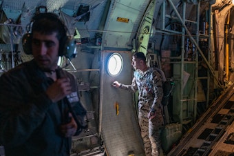 caption: Jordanian air force personnel inside a C-130 aircraft after airdropping pallets of aid over Gaza on Thursday.