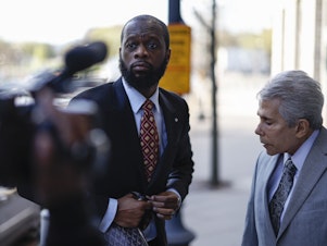 caption: Pras Michel, former member of the Fugees, center, and his lawyer David Kenner arrive to federal court in Washington, D.C., on April 3, 2023.