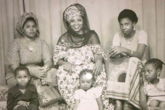 caption: Family portrait taken in Niger in 1978. Leila M’baye's great-grandma, Hadjia Mecca, smiles in the center of the top row. Hadjia's two daughters sit on either side of her, and her three grandchildren sit in the front row. Leila’s mom, Aissata M’baye, is on the lower right.