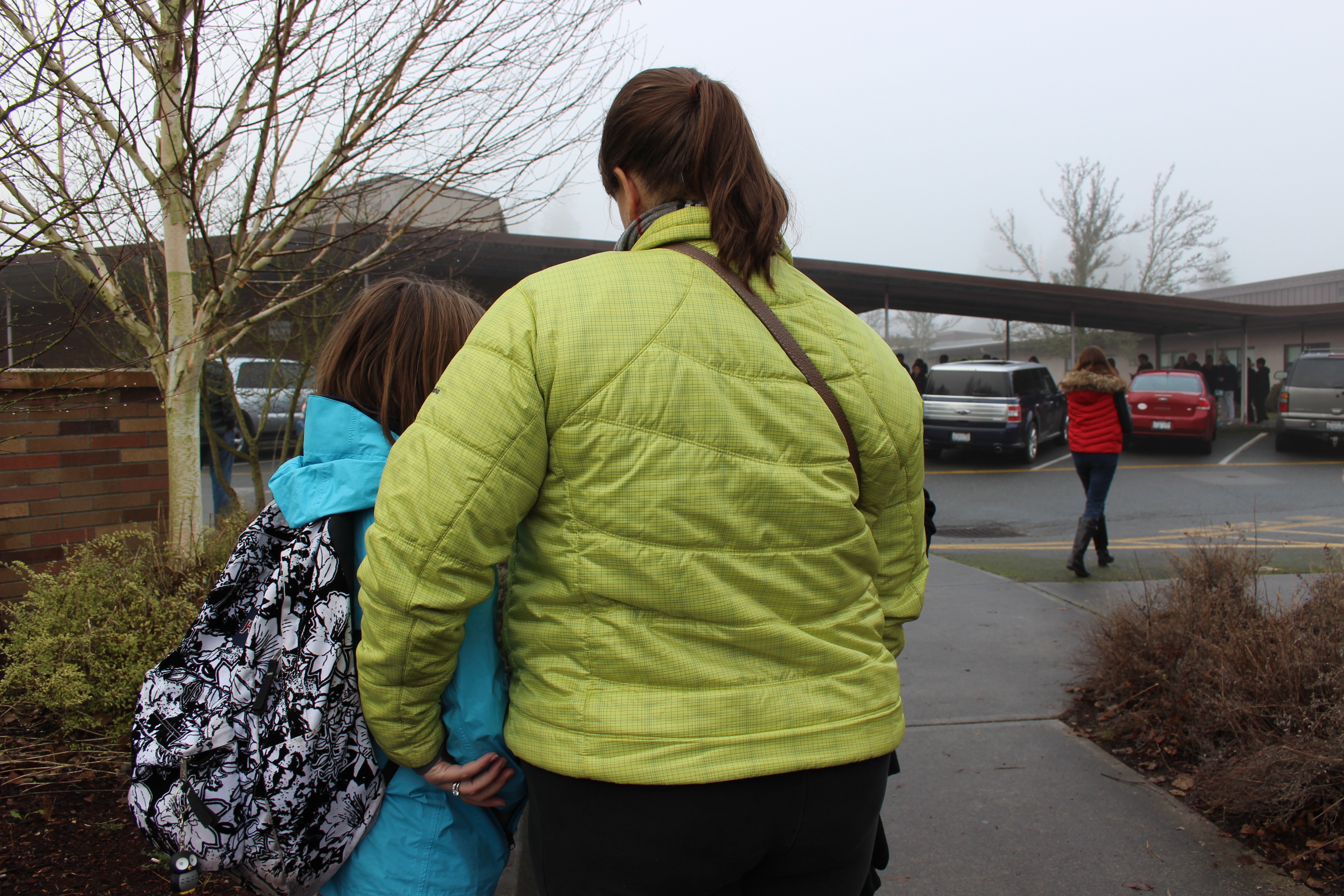 caption: Jessica Cote picks up her daughter, Anna Cote, at the Spartan Recreation Center in Shoreline after students were moved to that location for reunification Wednesday morning, Jan.7.