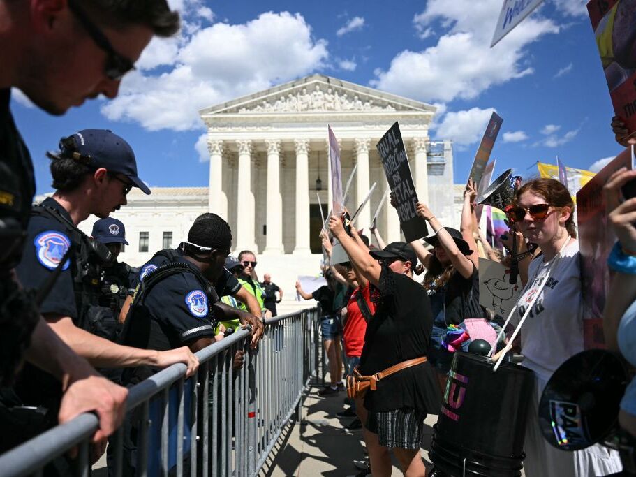 caption: U.S. Supreme Court Police officers put up barricades to separate anti-abortion activists from abortion rights activists during a demonstration in front of the Supreme Court in Washington, DC, on June 24, 2024. 