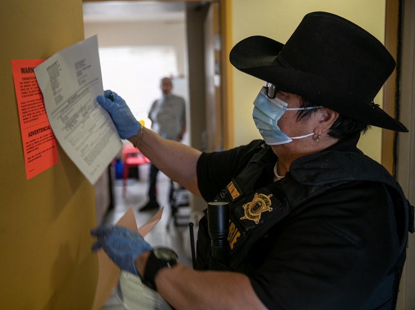 caption: A constable posts an eviction order for nonpayment of rent in October in Phoenix. The CDC is extending an order aimed at preventing evictions.
