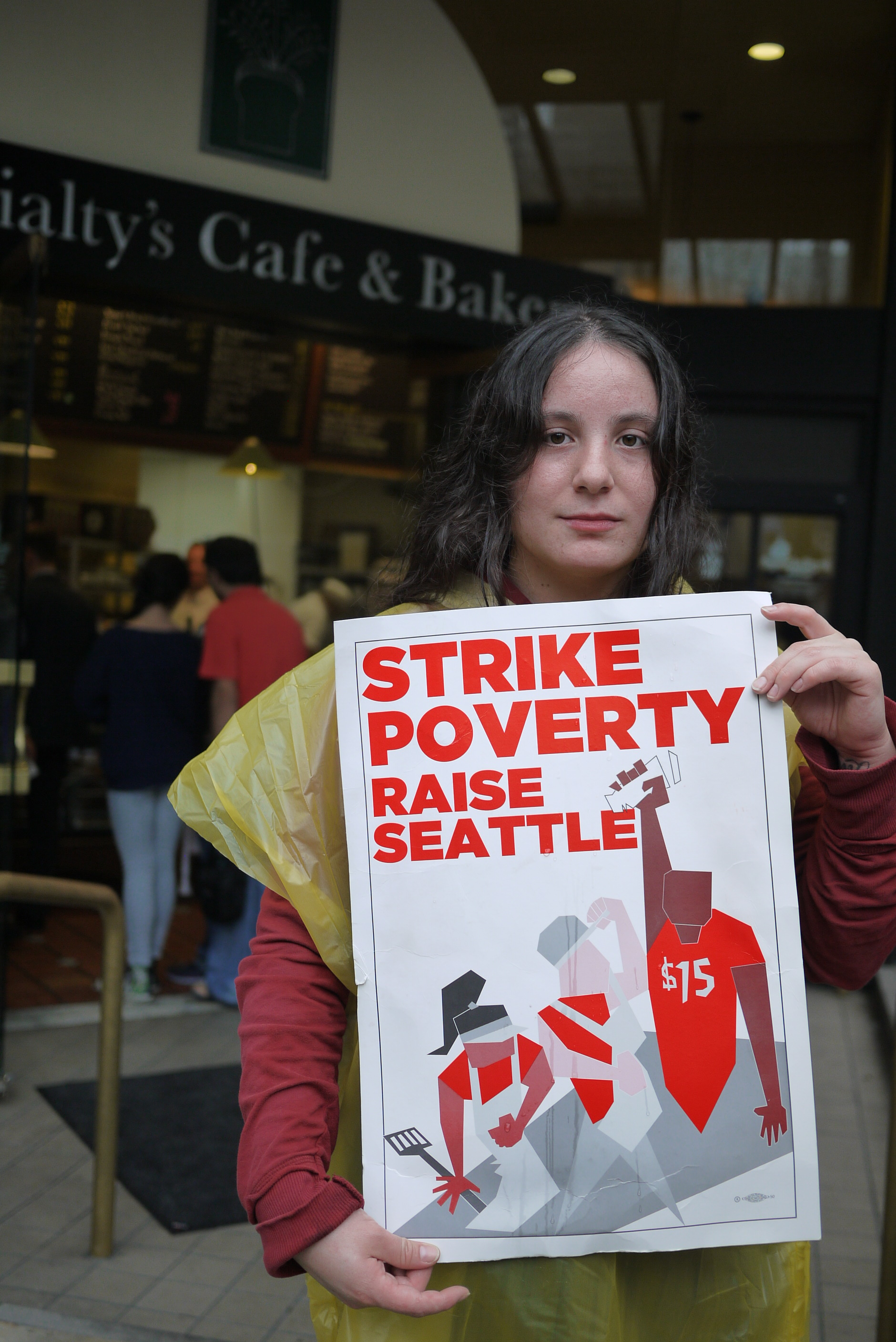 caption: A fast-food worker participates in a one-day strike to encourage a $15 minimum wage in Seattle.