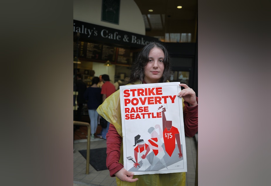 caption: A fast-food worker participates in a one-day strike to encourage a $15 minimum wage in Seattle.