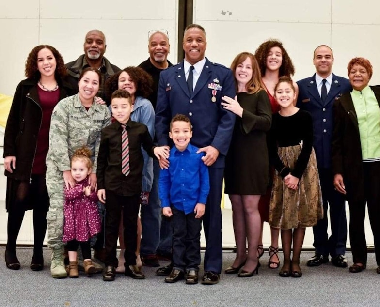 caption: The Oliver family poses for a photo at Dorien Oliver's husband Steve's retirement from the Air Force Reserves. Front row from left, Lilia, 4, Stephen, 11, and Spencer, 9; middle row from left, Isha ,26, Stephanie, 15, Steve, Dorien and Natalie,13; back row from left, Rayna, 24), the children's uncles Noel and David, Elise, 17), Kimer, 31), and their grandmother Marlene.