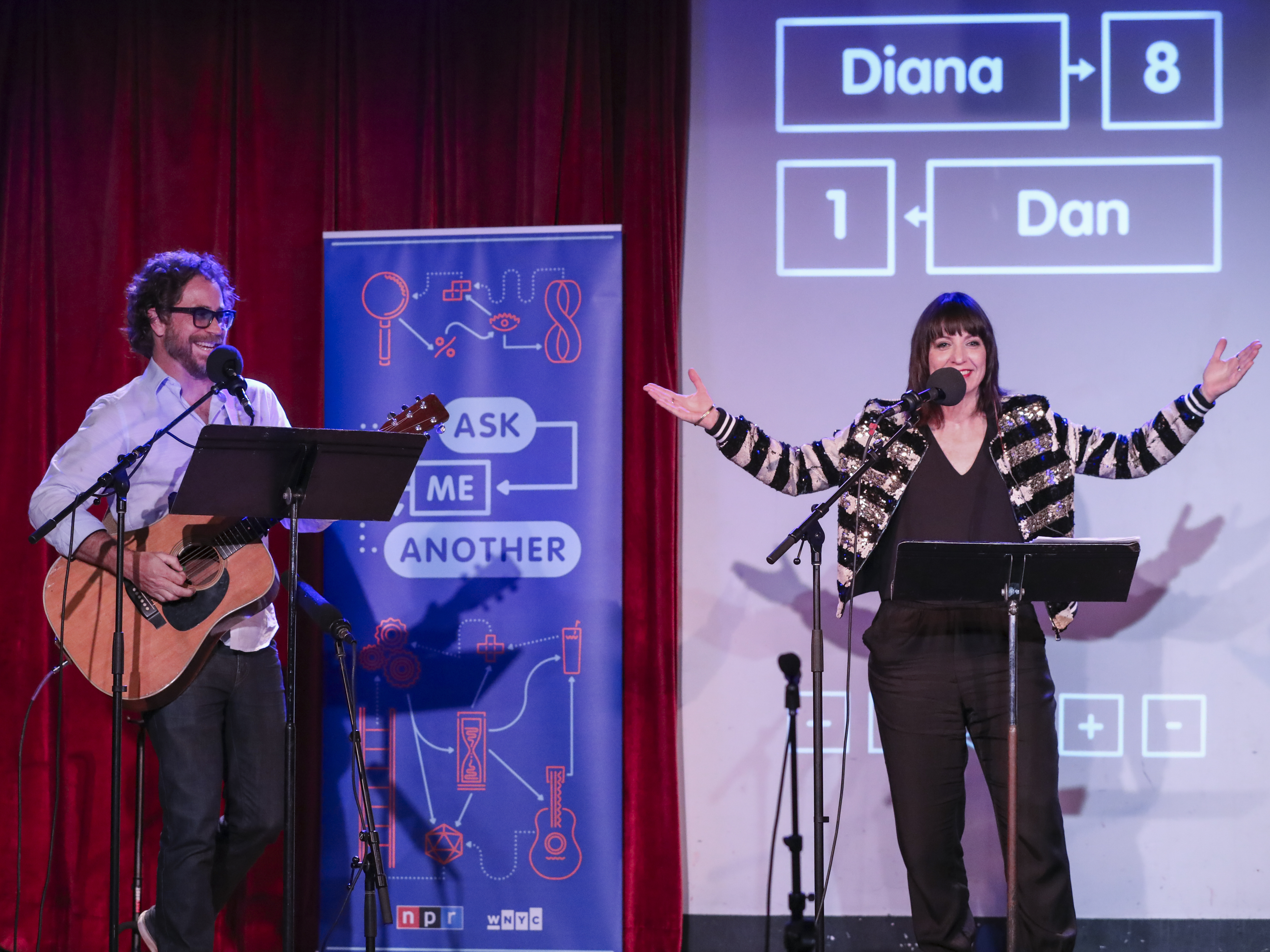 caption: Jonathan Coulton leads a music parody game alongside Ophira Eisenberg on <em>Ask Me Another</em> at the Bell House in Brooklyn, New York.