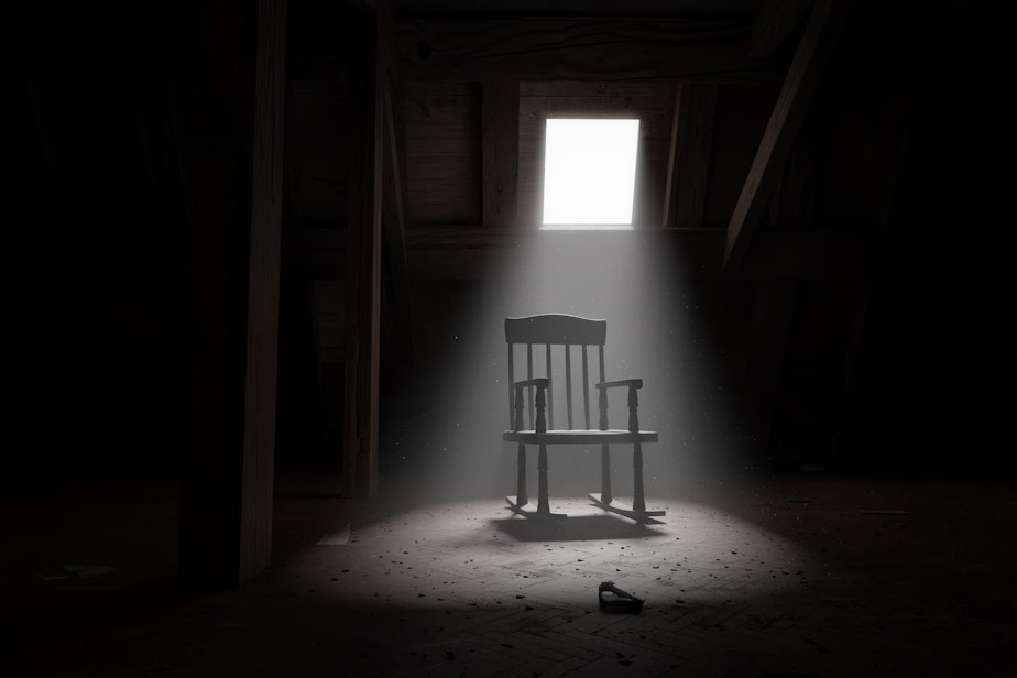An old rocking chair illuminated by light ray at dark attic