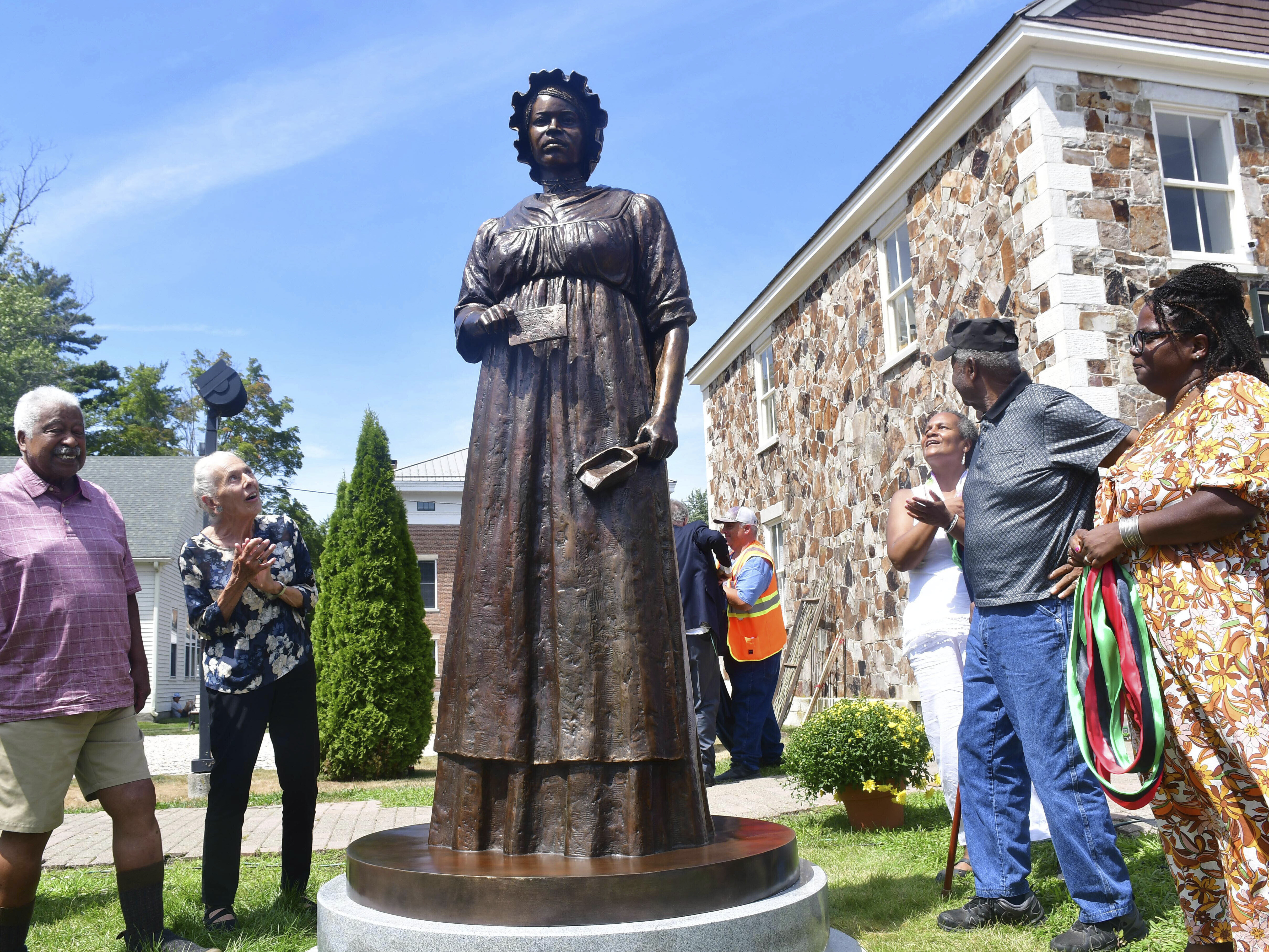 caption: A monument of civil rights pioneer Elizabeth Freeman is unveiled in front of Sheffield's Old Parish Church in Sheffield, Mass., Sunday, Aug. 21, 2022.