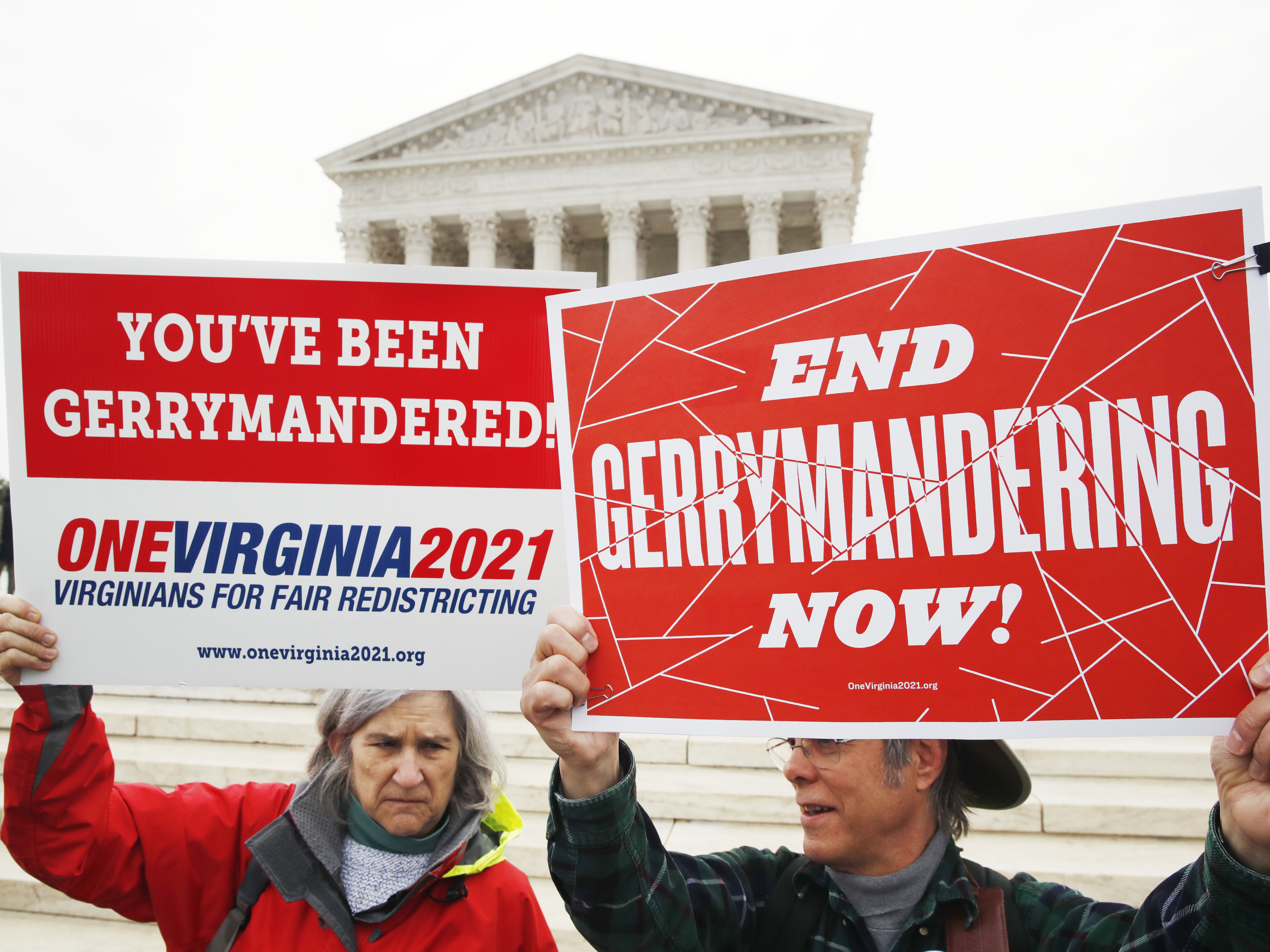 caption: Sara Fitzgerald (left) and Michael Martin, both with the group One Virginia, protest gerrymandering in front of the Supreme Court in March.
