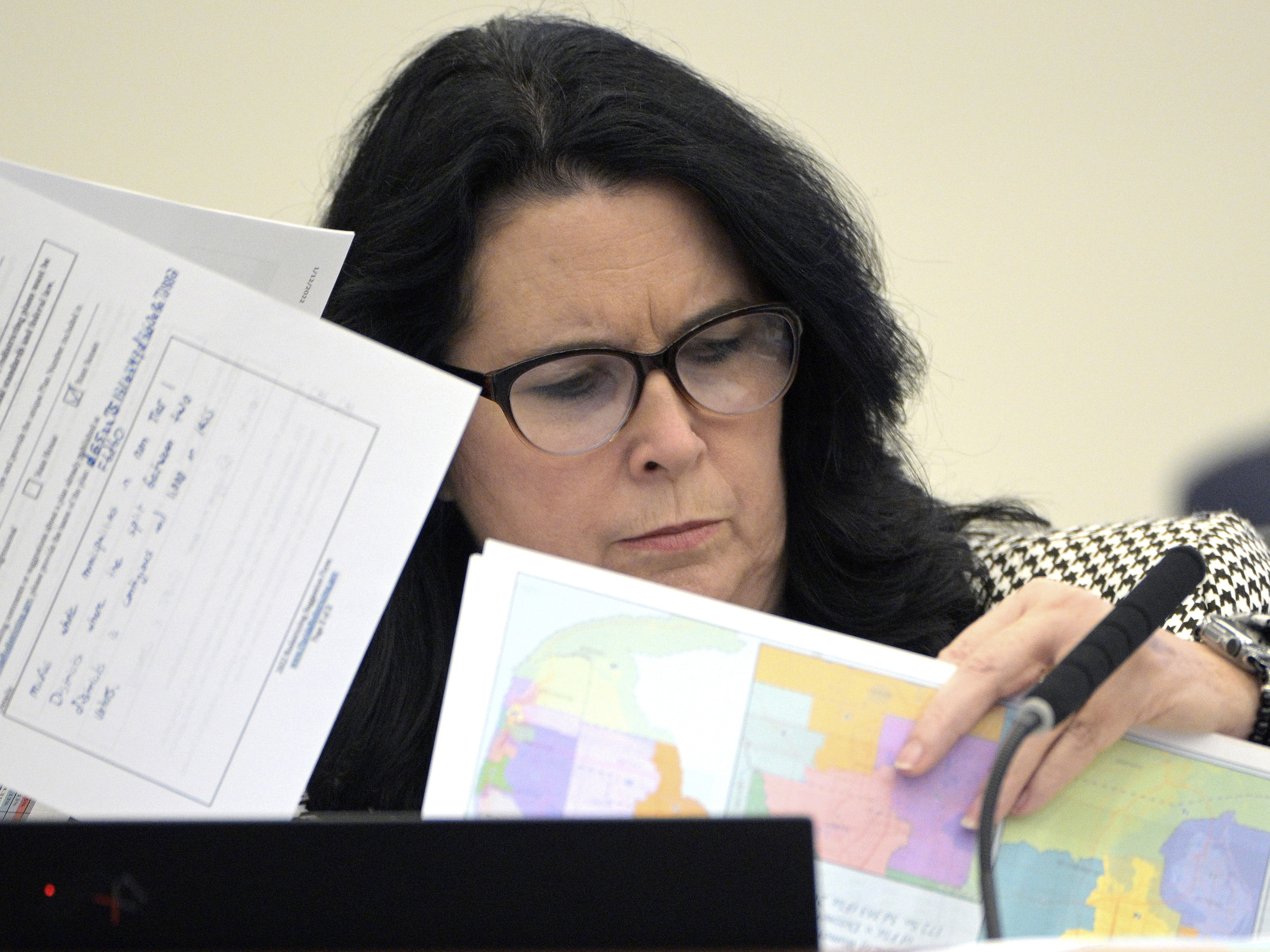 caption: State Sen. Kelli Stargel looks through redistricting maps during a Senate Committee on Reapportionment hearing on Jan. 13, 2022, in Tallahassee, Fla. A Florida redistricting plan pushed by Gov. Ron DeSantis violates the state constitution, a state judge ruled Saturday.