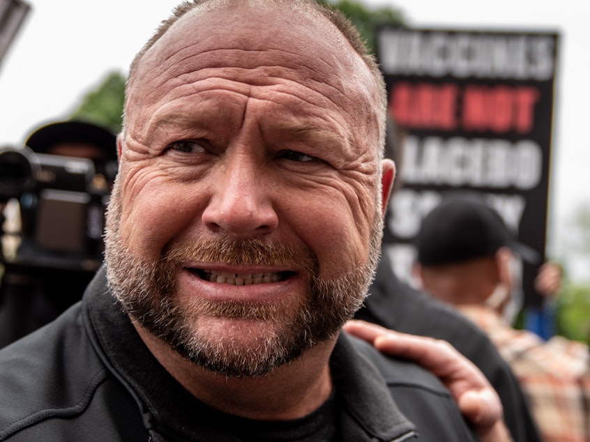 caption: Infowars founder Alex Jones interacts with supporters at the Texas State Capital building on April 18, 2020, in Austin.