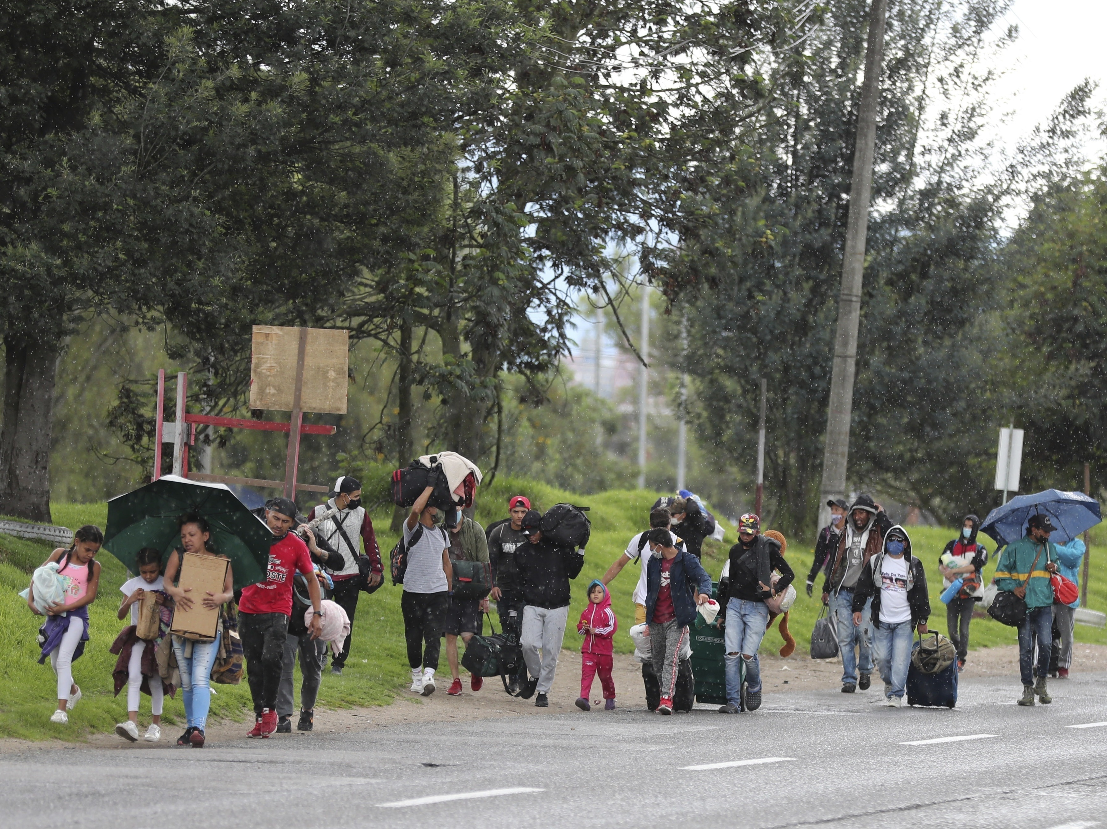 caption: Venezuelan migrants in Colombia walk toward the border amid the coronavirus lockdown. Colombian officials say 12,000 Venezuelans have taken buses back to their home country since Colombia imposed restrictions to stop the outbreak.