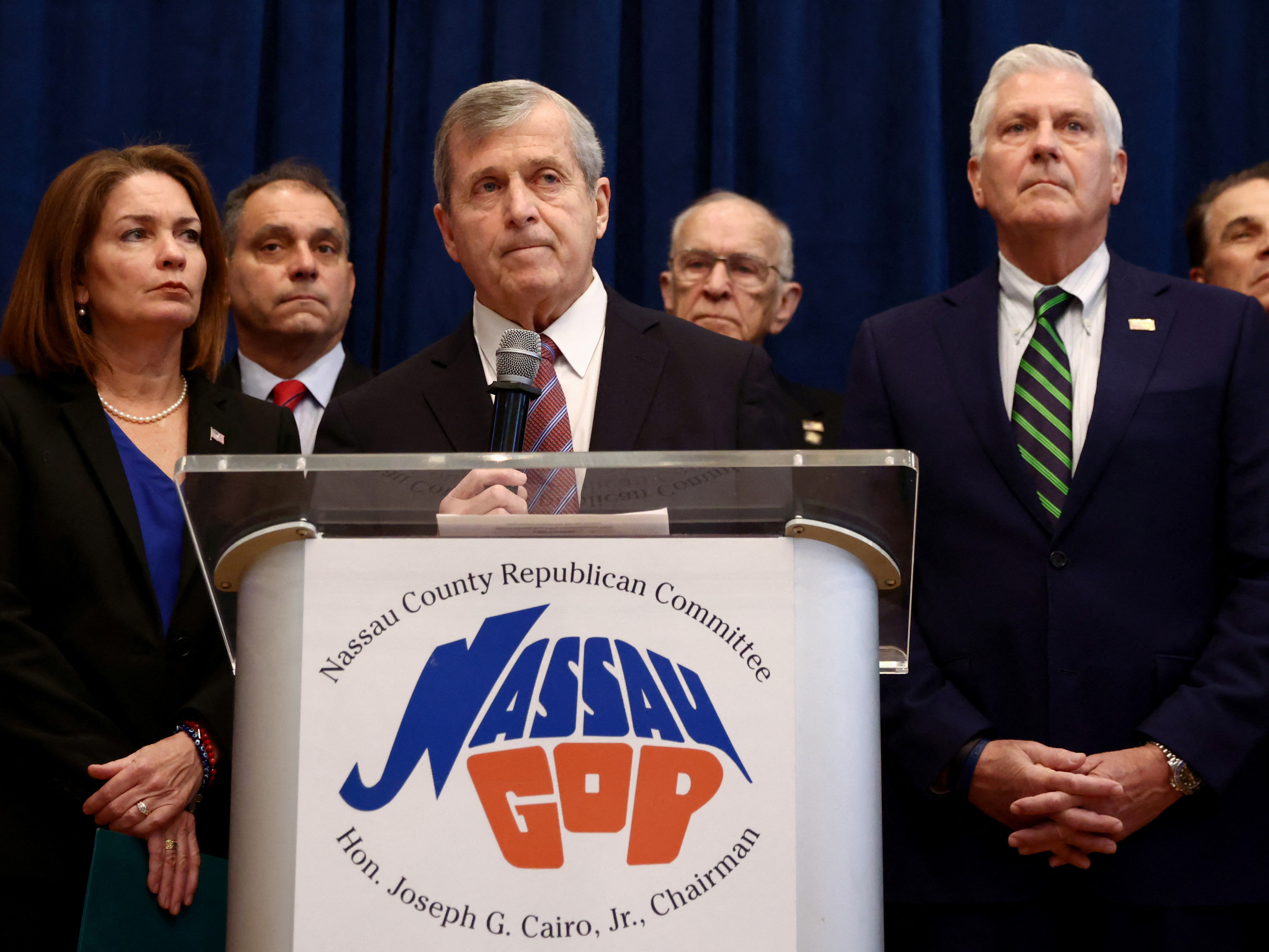 caption: Nassau County Republican Party chairman Joseph Cairo and members of the Nassau County Republican Committee hold a news conference regarding the future of U.S. Representative George Santos at Nassau County Republican Committee in Westbury, New York.
