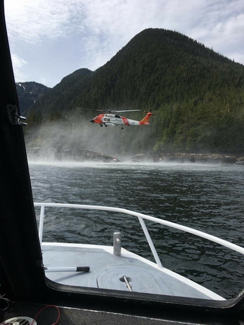 caption: A Coast Guard Air Station Sitka MH-60 Jayhawk helicopter crew hovers while searching for a survivor from a report of two aircraft colliding in the vicinity of George Inlet near Ketchikan, Alaska, May 13, 2019. Ten survivors of the crash had reportedly swam to shore and were rescued by Coast Guard aircrews while the search continues for two people still reported to be missing from the crash.