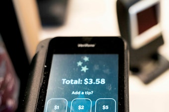 caption: Tip options are displayed on a card reader at a store in Washington, D.C., on March 17, 2023.