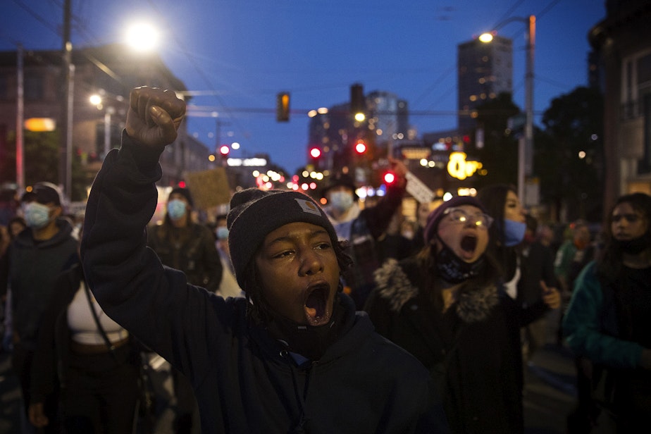 caption: Tealshawn Turner leads a group of people protesting police brutality and violence against Black Americans back to the Capitol Hill Occupied Protest zone after marching to the Seattle Police Department's West Precinct building on the 19th day of protests in Seattle following the violent police killing of George Floyd, on Tuesday, June 16, 2020.