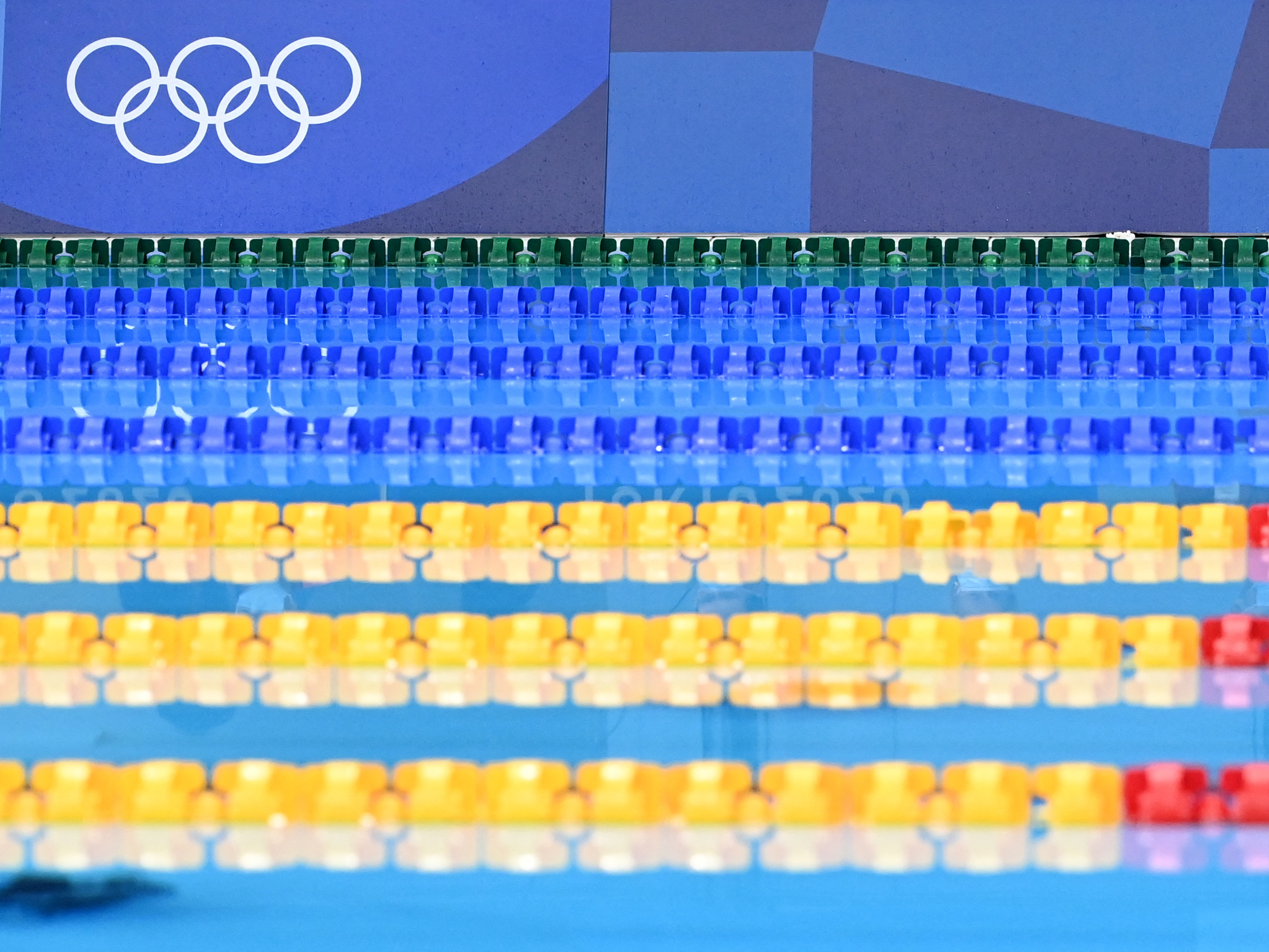 caption: Empty lanes are pictured ahead of a heat for a swimming event during the Tokyo 2020 Olympic Games at the Tokyo Aquatics Center.