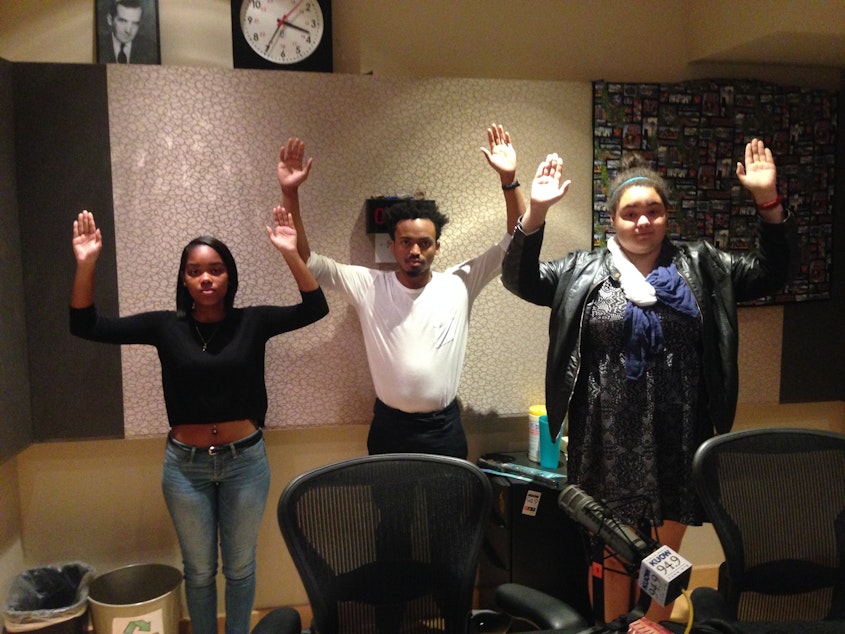caption: Yaninna Sharpley-Travis (left), Marcel Purnell and Devan Rogers. They are making the "don't shoot" pose, which has become a popular form of social media protest after the events in Ferguson.
