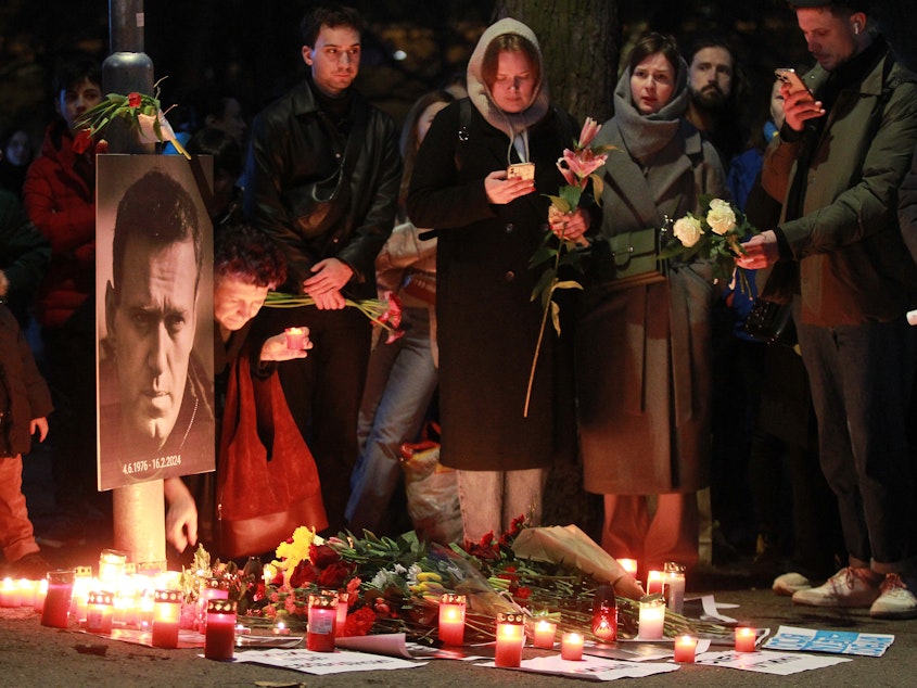 caption: Protesters light candles on Friday in front of the Russian Embassy in Prague after the announcement that the Kremlin's most prominent critic, Alexei Navalny, had died in an Arctic prison.