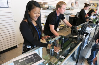 caption: Employees at Ike's Pot Shop in Seattle's Central District sell marijuana products on their opening day, Sept. 30, 2014.