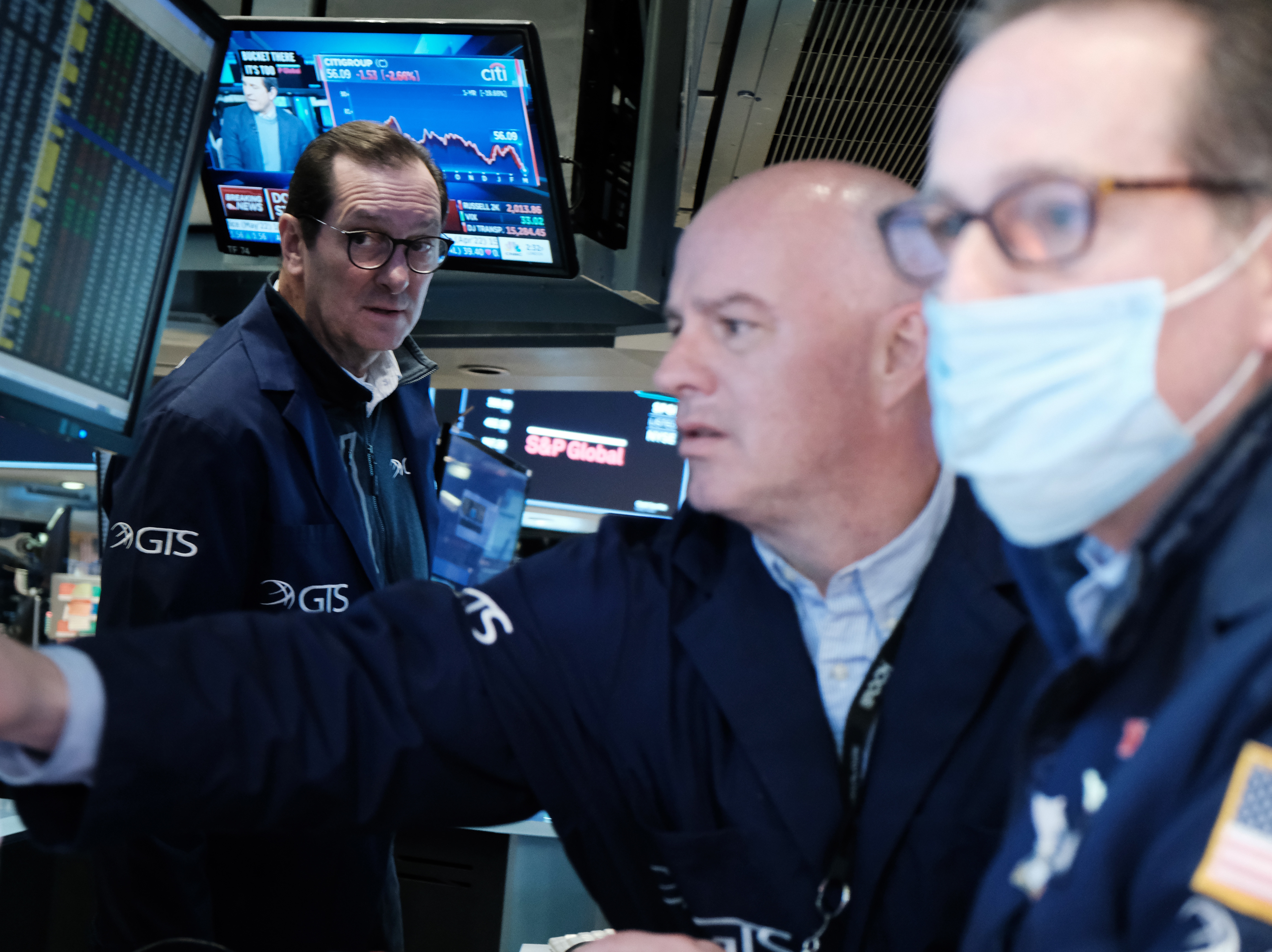 caption: Traders work on the floor of the New York Stock Exchange (NYSE) in New York City on March 4. The Dow slumped nearly 800 points on Monday, entering what's called a correction.