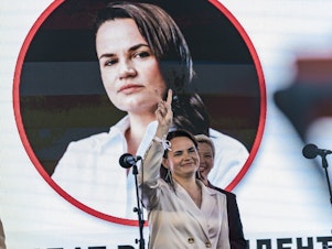 caption: Svetlana Tikhanovskaya, presidential candidate in Belarus elections 2020, makes the symbol of victory in a rally in Minsk.
