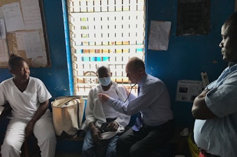 caption: Dr. Paul Farmer examines a tuberculosis patient in Monrovia, Liberia.