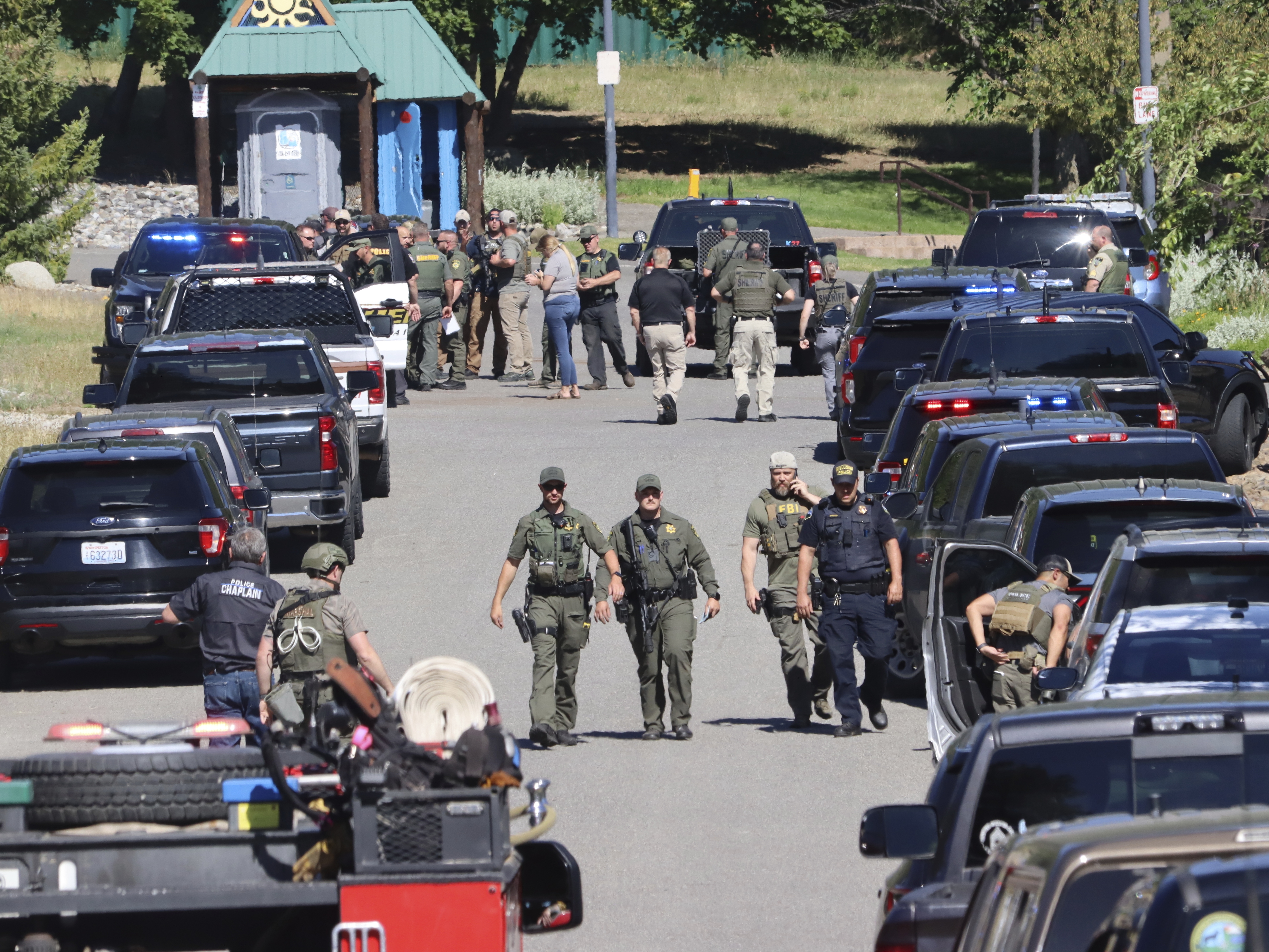caption: Law enforcement and emergency responders are shown on Sunday afternoon following reports of an ambush shooting attack on Canfield Mountain, in Coeur d'Alene, Idaho.