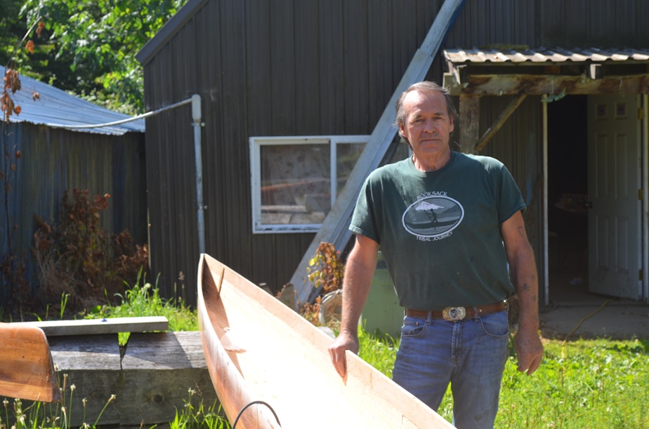 caption: George Swanaset Sr. with one of the racing canoes he crafts in Everson, Washington.