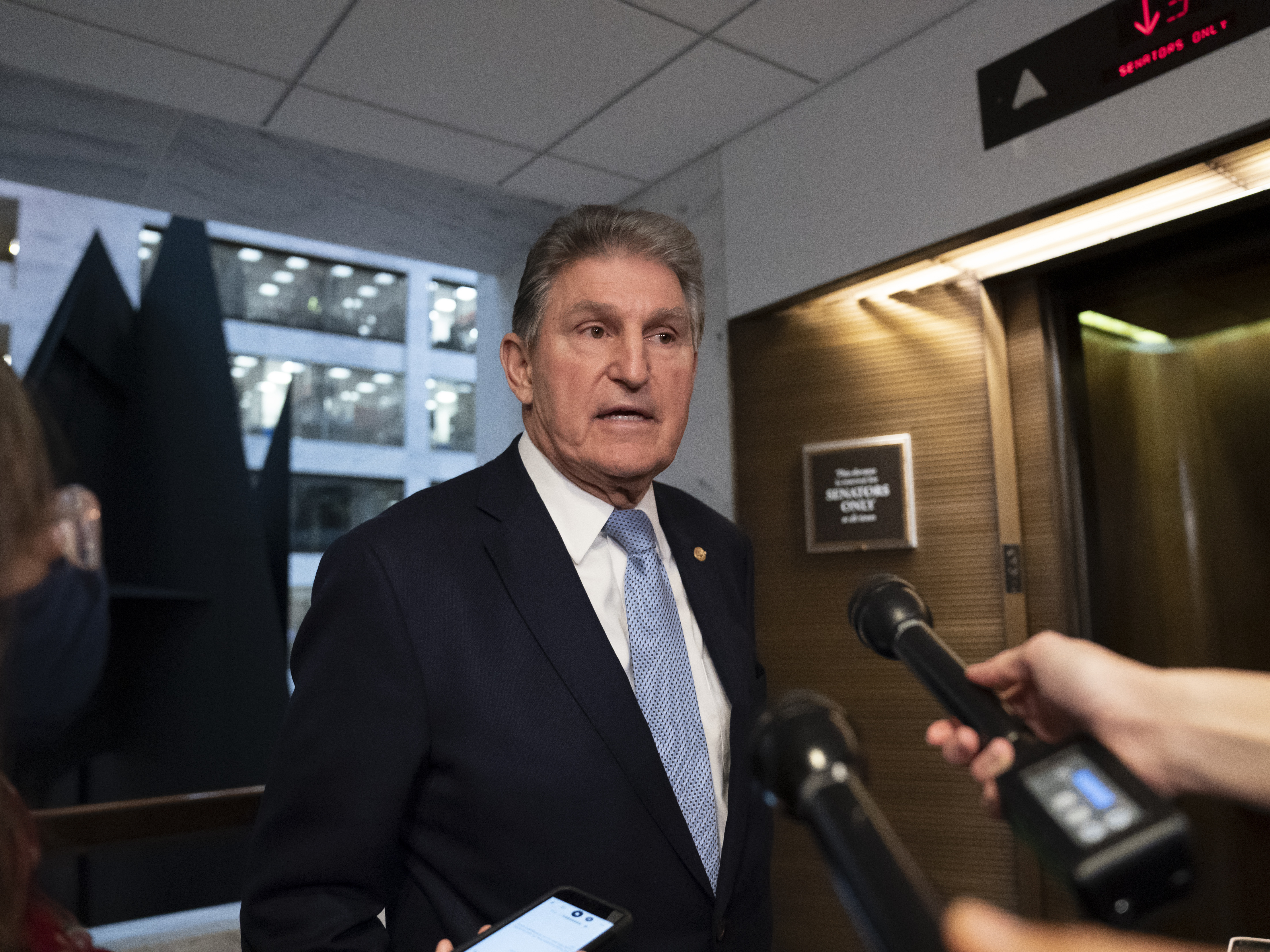 caption: Sen. Joe Manchin (D-W.Va.) leaves his office after speaking with President Joe Biden about his long-stalled domestic agenda, at the Capitol in Washington, Monday, Dec. 13.