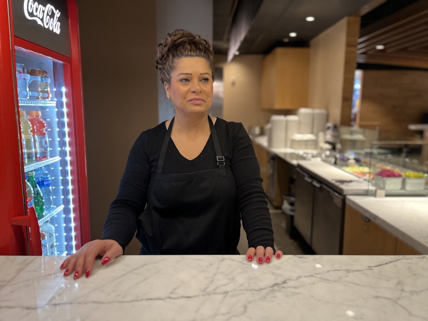 caption: Leyla Farange stands behind the counter at Gyros Place in the food court under Twitter's old offices at Century Square across 4th Avenue from Westlake Park.