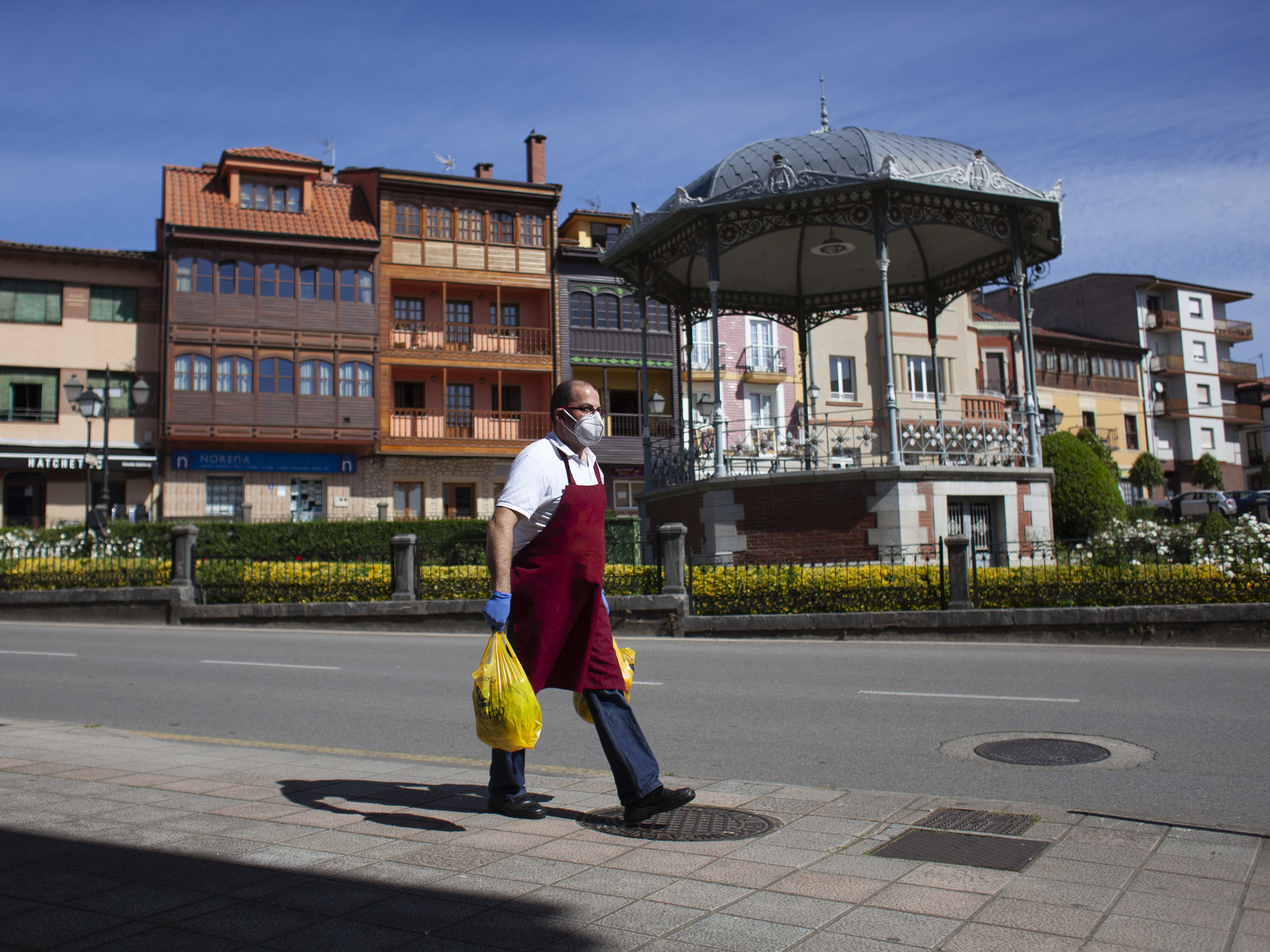 caption: The new EU economic forecast reflects a total drop of 9 percentage points since last fall's forecast, as businesses have been shut down or forced to operate at severely limited capacity. Here, a man delivers a butcher shop order in Norena, Spain, on Wednesday.