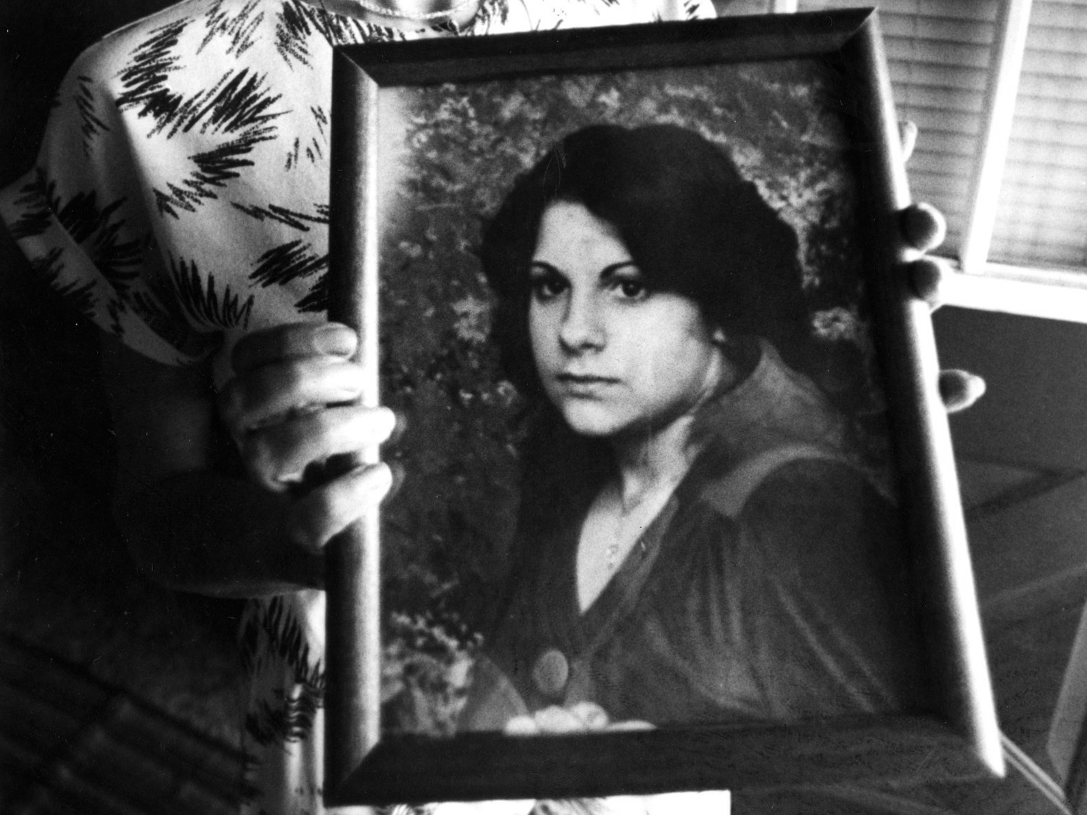 caption: Judy Chartier holds a photograph of her missing daughter, also named Judith "Judy" Chartier, in May 1990. The car belonging to Judith and her remains were discovered nearly 40 years later.