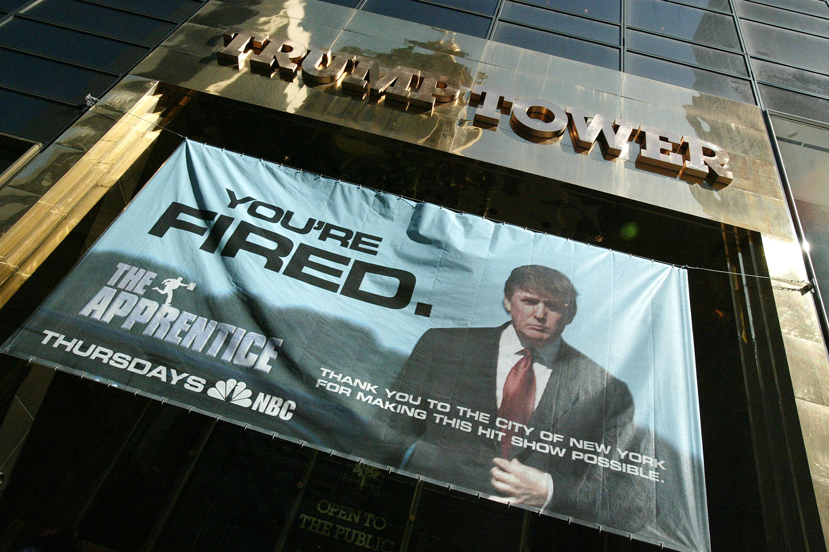 caption: A sign advertising the television show "The Apprentice" hangs at Trump Towers April 15, 2004 in New York City.  (Peter Kramer/Getty Images)