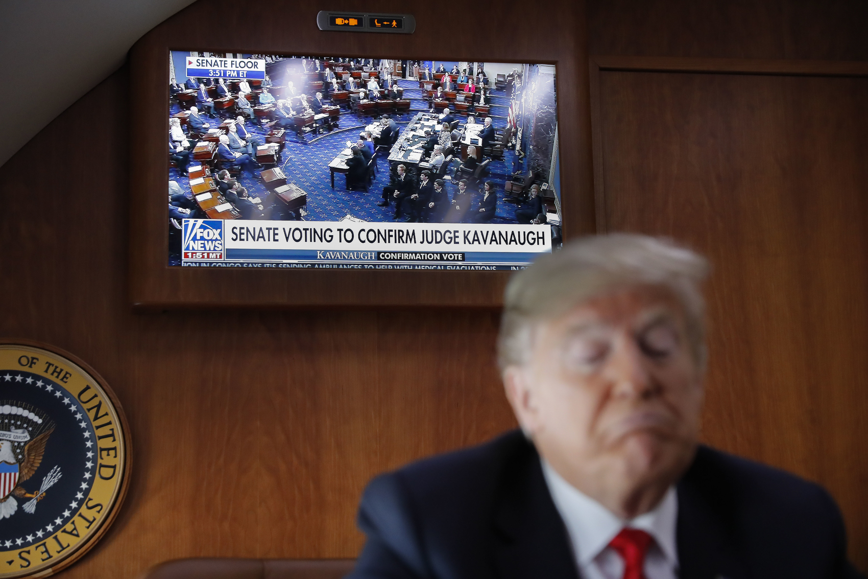 caption: A live television broadcast of the Senate confirmation vote of Supreme Court nominee Brett Kavanaugh is displayed with President Donald Trump, on board Air Force One, Saturday, Oct. 6, 2018. Trump was traveling from Washington enroute to Topeka, Kan., for a campaign rally. (AP Photo/Pablo Martinez Monsivais)