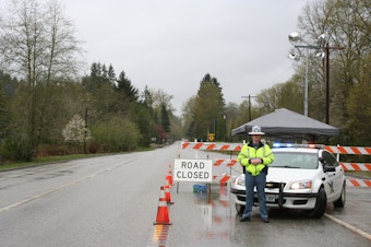 caption: A State Patrol post blocks cars from traveling west on state Route 530 out of Darrington, Wash.