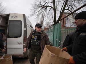 caption: Serhii Chaus, the mayor of the eastern Ukrainian city of Chasiv Yar, arrives at a bread delivery location on the outskirts of town. Chaus goes daily into the embattled town to deliver supplies and meet residents who choose to stay there as Russian forces are approaching the area.