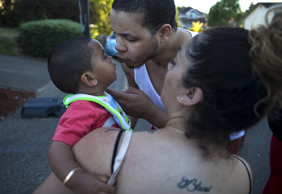 caption: DaShawn Horne kisses his son Deion, now 2, held by his mother Vanessa, on Thursday, July 26, 2018, after playing basketball in front of the Horne's home in Auburn. 