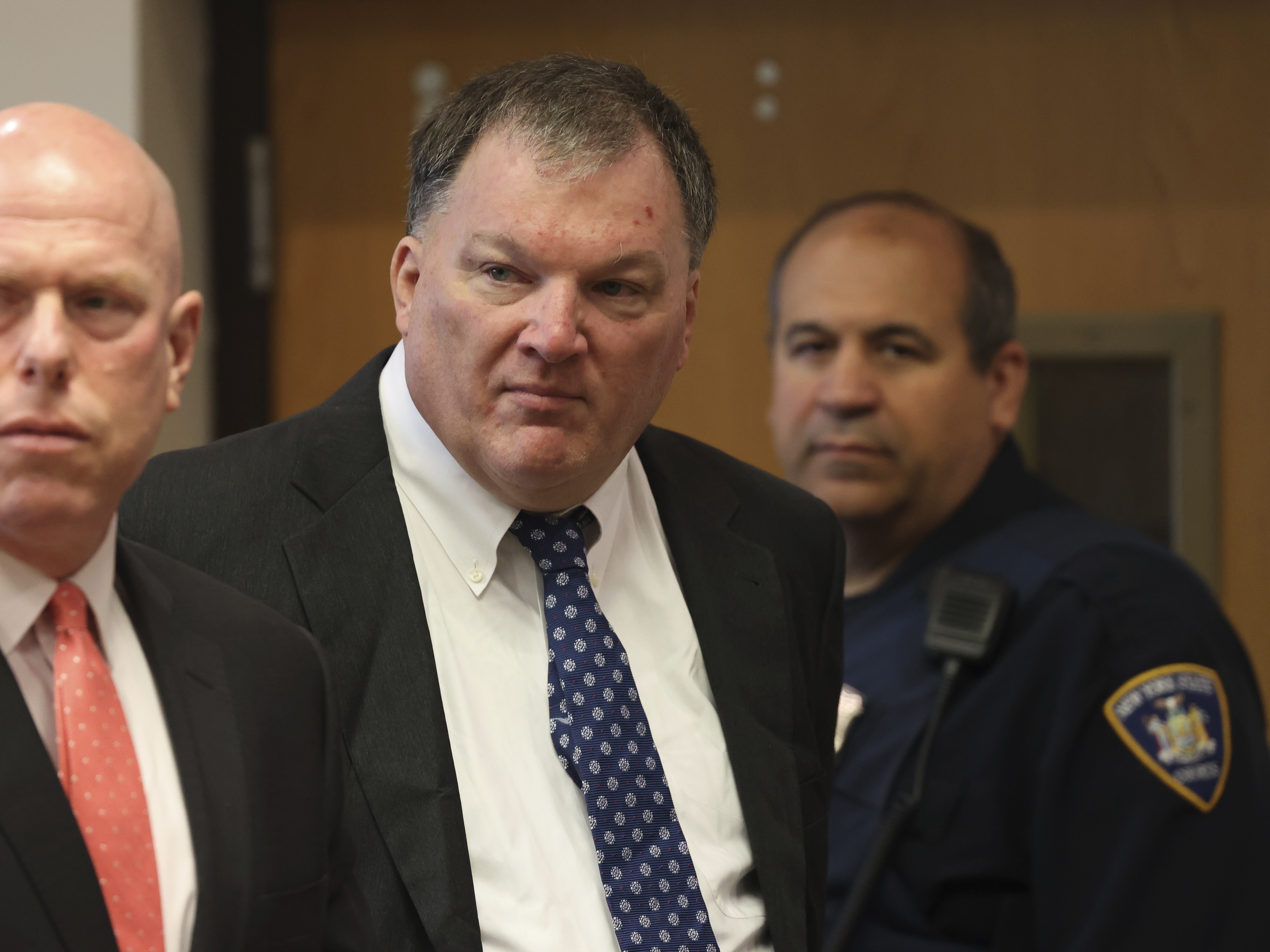 caption: Rex Heuermann (center) charged in the Gilgo Beach serial killings on Long Island, appears for a hearing on July 30 at Suffolk County Court in Riverhead, N.Y.