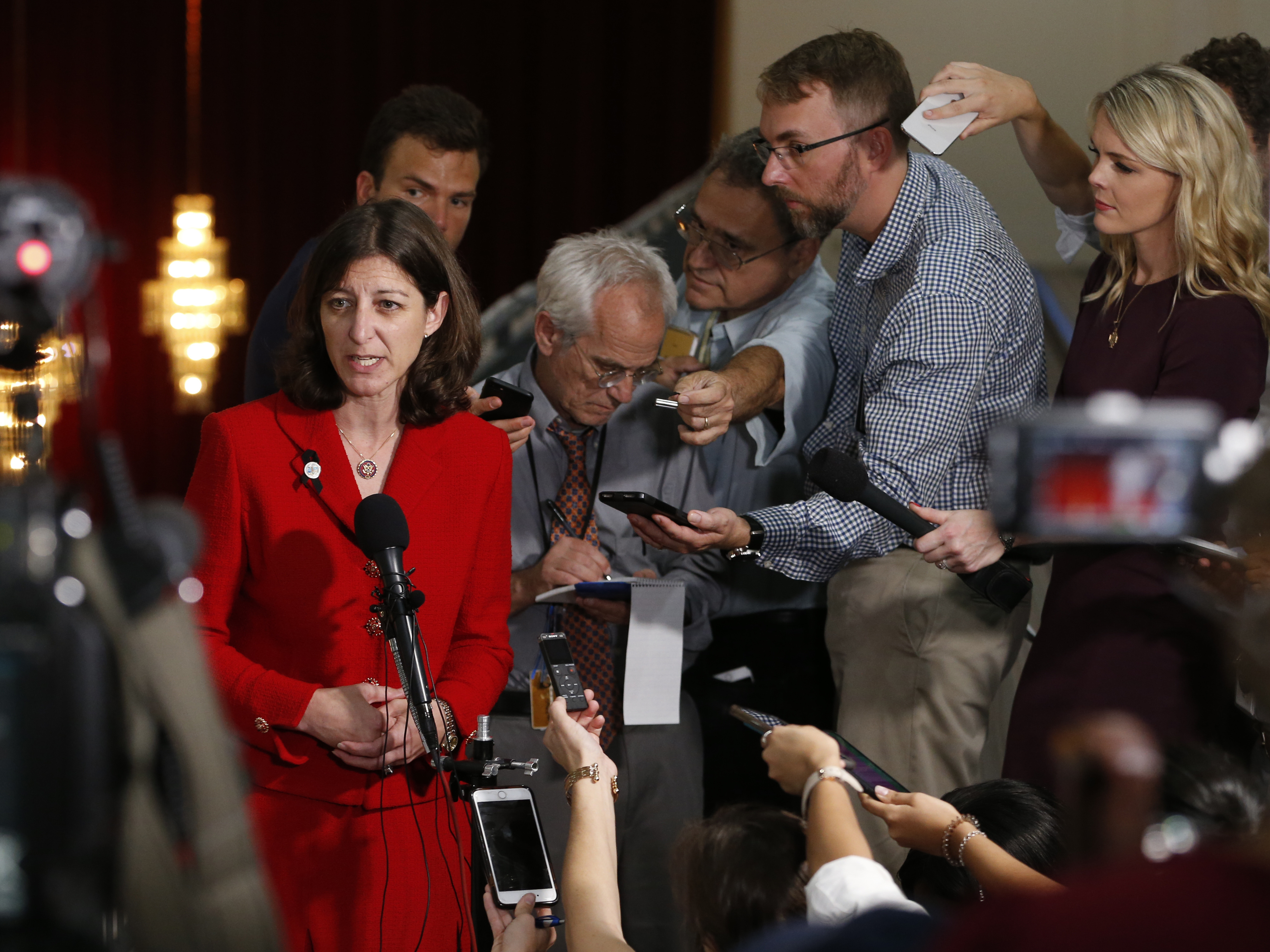 caption: Rep. Elaine Luria answers reporters' questions prior to a town hall at a church in Virginia Beach, Va., in October.