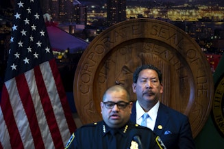 caption: Seattle mayor Bruce Harrell looks on as former Seattle police chief Adrian Diaz addresses members of the press during a press conference where it was announced that he’d be stepping down, on Wednesday, May 29, 2024, at City Hall in Seattle. 