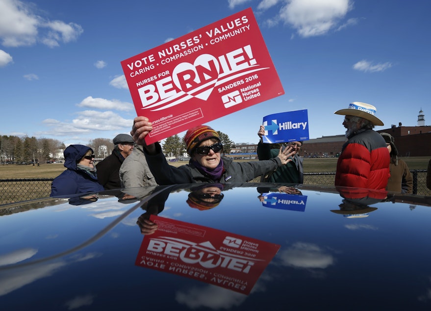 caption: Claudine Weatherford of Peaks Island, Maine, shows her support for Democratic presidential candidate Bernie Sanders as she tries to block her brother-in-law, Jeremy Wyant, a Hillary Clinton backer, while waiting in line at a Democratic caucus on Sunday.