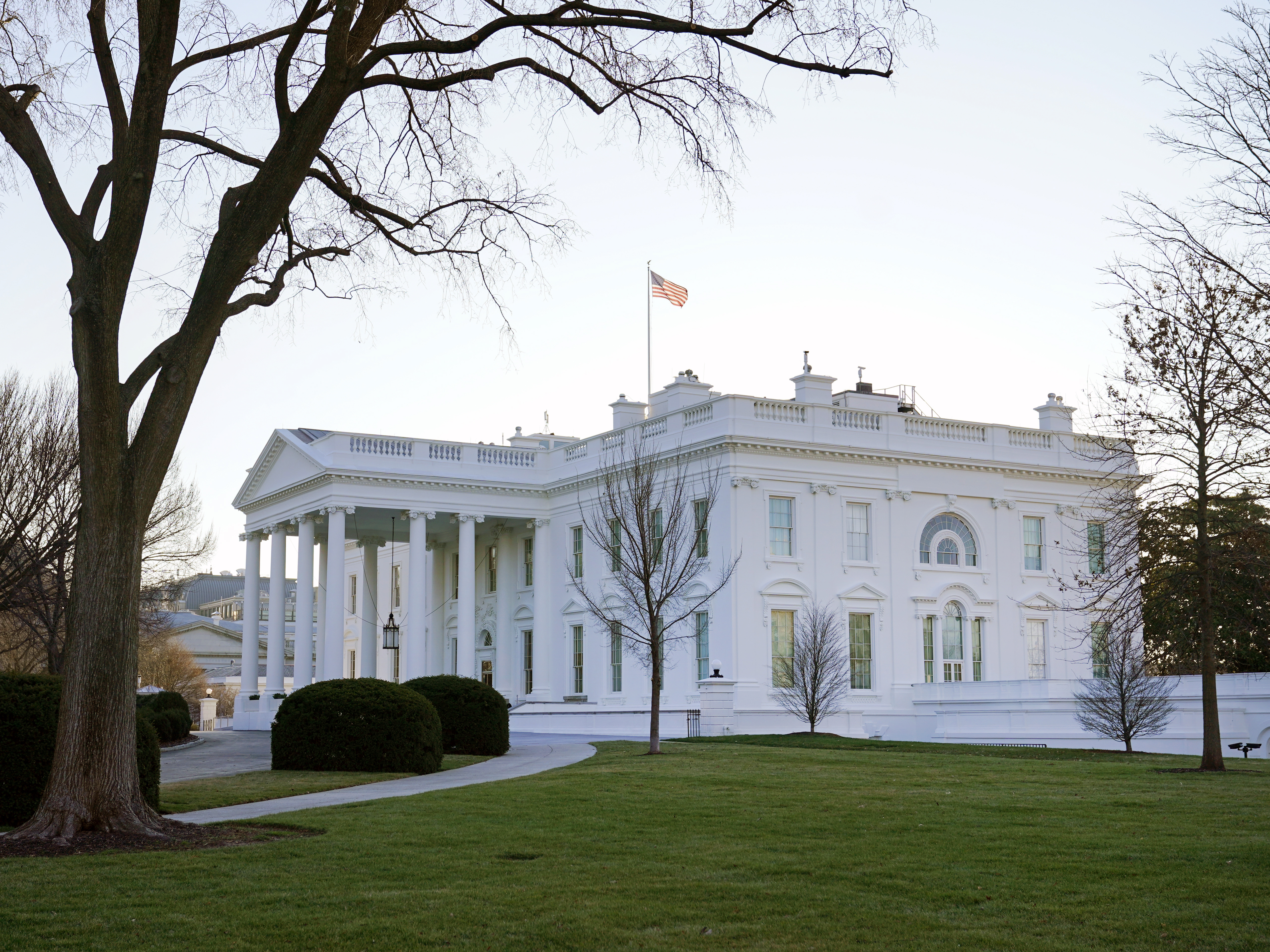 caption: An American flag flies over the White House on Thursday.