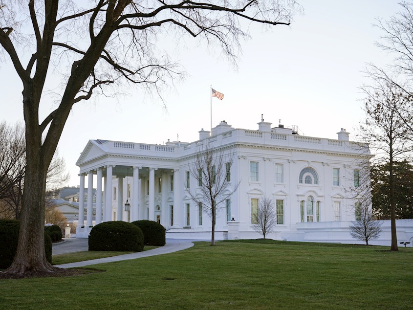 caption: An American flag flies over the White House on Thursday.